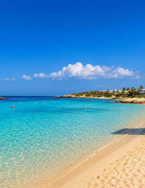 Blue Flag beach in Ayia Napa with crystal-clear turquoise water, golden sand and a lifeguard tower.